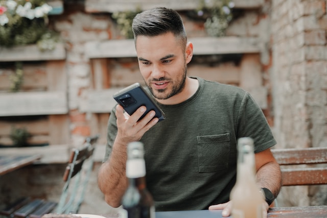 Man playing online casino on his smartphone while sitting outdoors