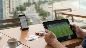 A person holding a tablet with an open website showing sports betting platform